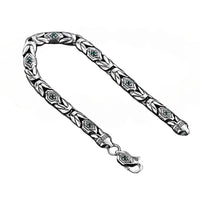Bracelet homme tendance en argent 925 maille balinaise sur fond blanc, bijou artisanal avec pierres en zircon vert.