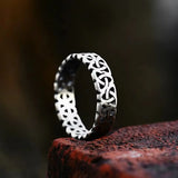 Anneau viking en acier, bague nordique brute posée sur pierre rouge