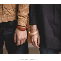 Bracelets en cuir portés par un couple – version beige et marron du modèle "Imagination"
