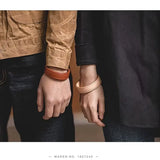 Bracelets en cuir portés par un couple – version beige et marron du modèle "Imagination"