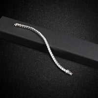 Bracelet tennis homme en pierres scintillantes (moissanite ou zircon), souple et élégant sur son écrin noir.