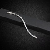 Bracelet tennis homme en pierres scintillantes (moissanite ou zircon), souple et élégant sur son écrin noir.