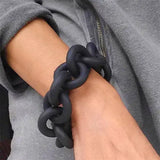 Bracelet upcyclé caoutchouc noir porté sur poignet, accessoire éthique et tendance pour un look urbain