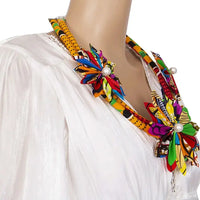 Collier en wax porté sur une tenue blanche, fleurs colorées en tissu wax cousues main