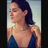 Femme portant un collier ras de cou en turquoise naturelle sur la plage – style bohème chic